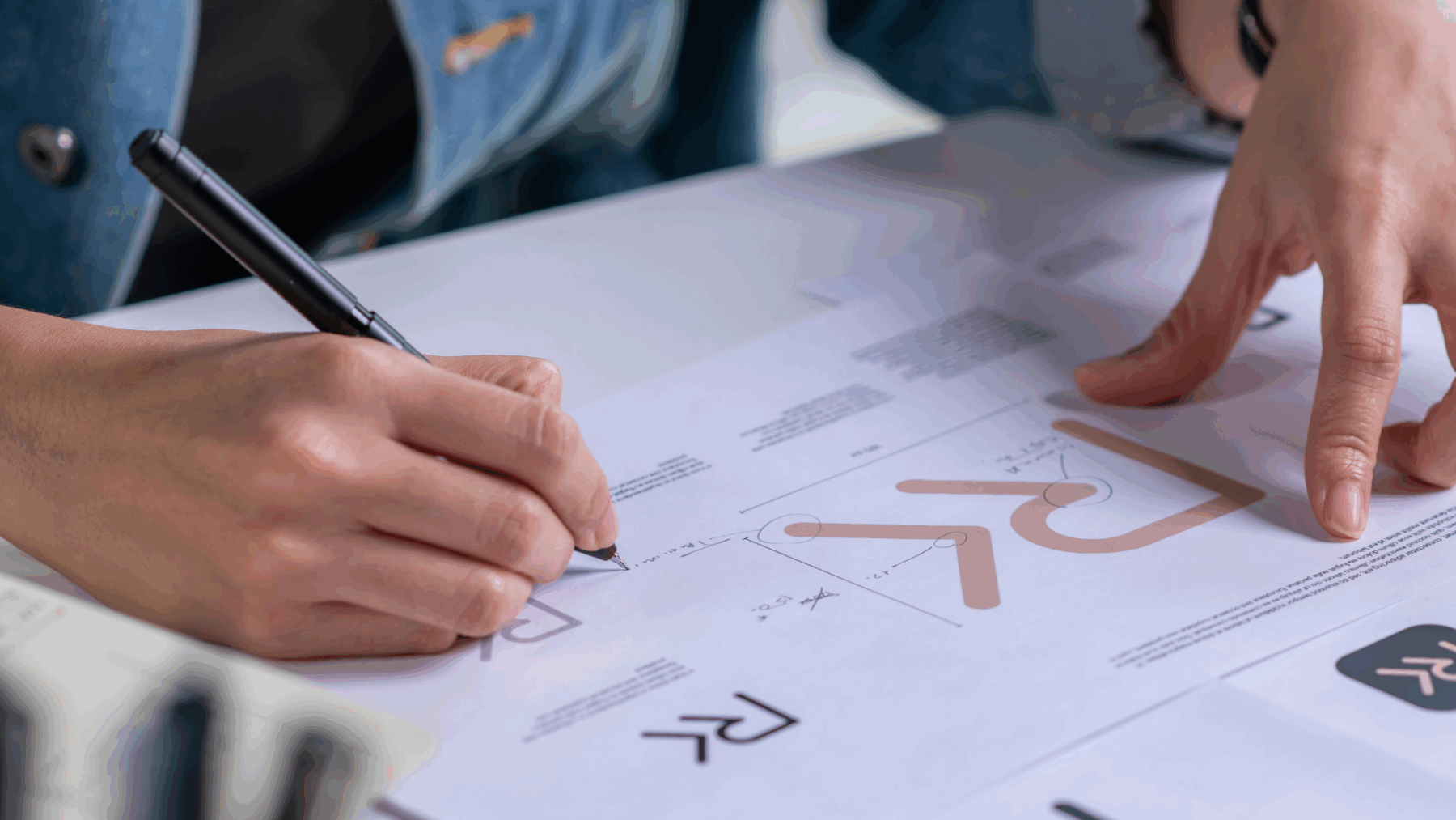 Rebranding strategy meeting where a marketing lead reviews brand guidelines.